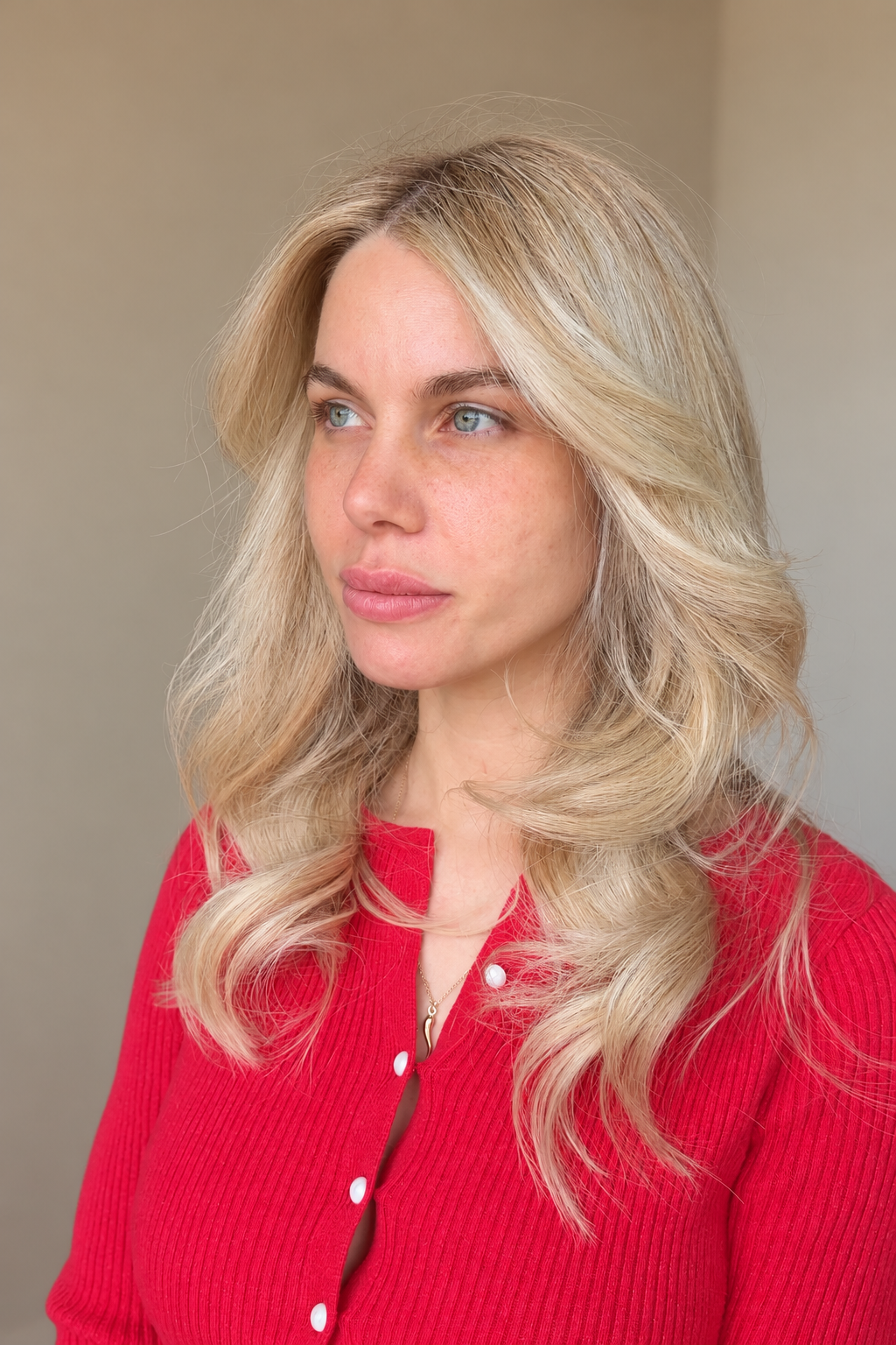 Client with dimensional blonde curls and a red cardigan